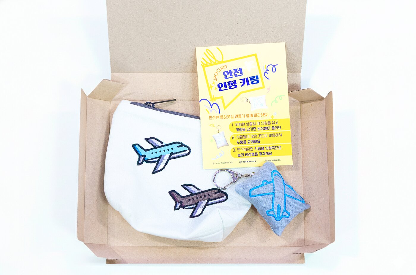 본문 이미지 - 대한항공의 테이블보와 대한항공·아시아나항공의 객실승무원 폐유니폼을 활용해 제작한 '업사이클링' 인형 키링과 파우치의 모습(대한항공 제공). 2025.12.29.