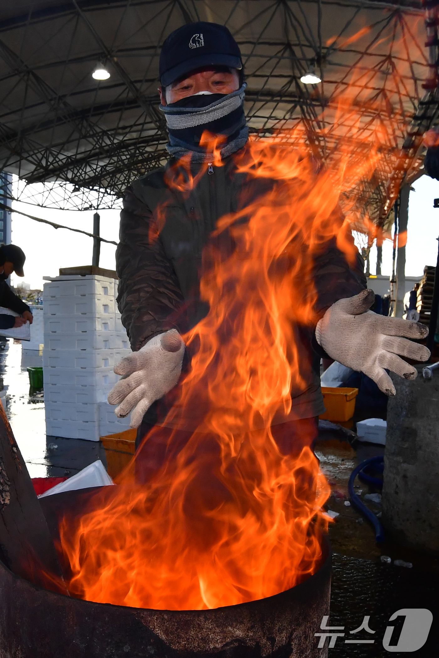 (포항=뉴스1) 최창호 기자 = 경북 포항 지역 아침기온이 영하권까지 떨어진 3일 포항시 죽도어시장에서 상인들이 장작불에 몸을 녹이고 있다. 2025.12.3/뉴스1