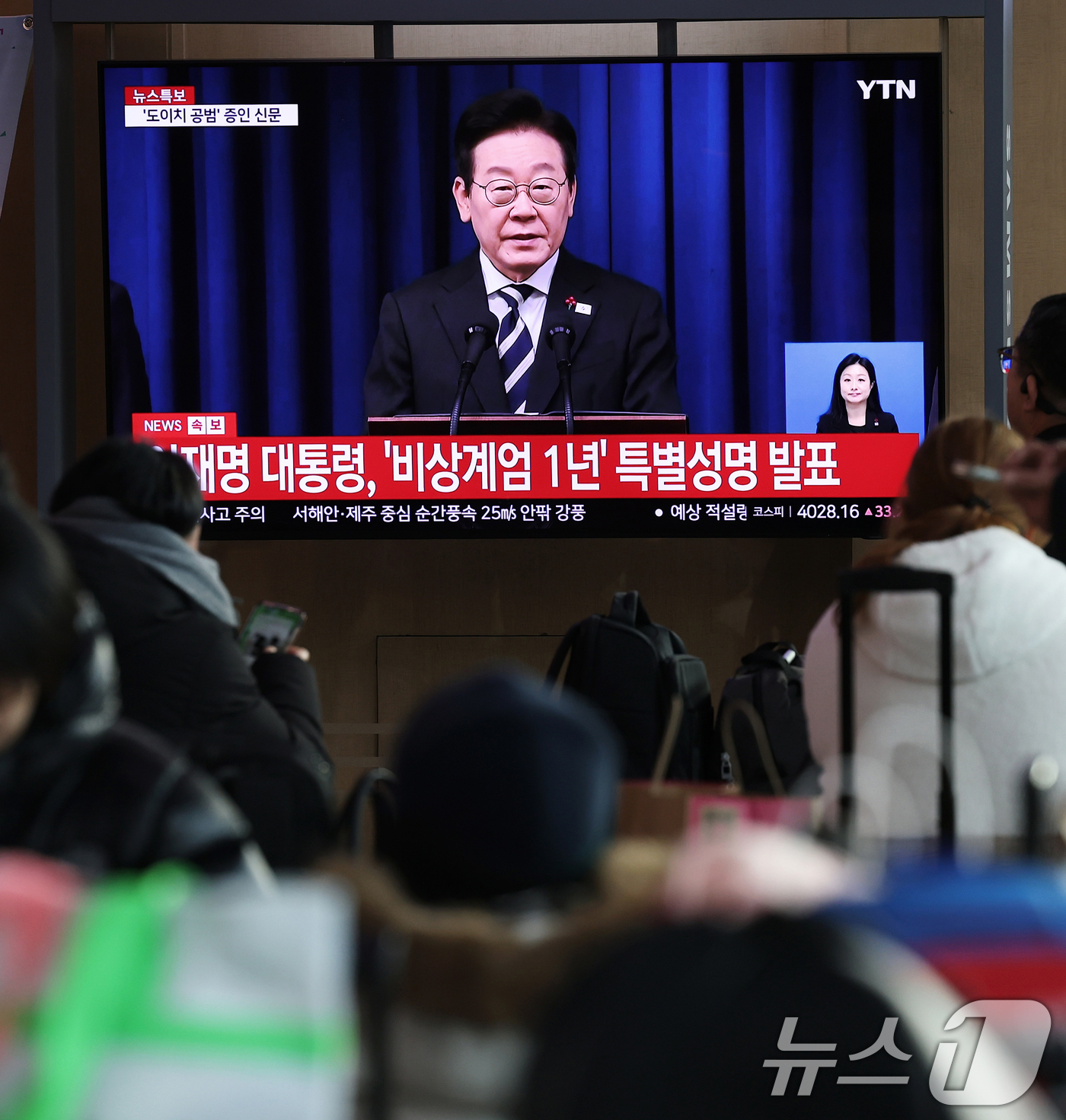(서울=뉴스1) 오대일 기자 = 12·3 비상계엄 1년을 맞은 3일 오전 서울 중구 서울역 대합실에서 시민들이 이재명 대통령의 '빛의 혁명 1주년' 대국민 특별성명 생중계를 지켜보 …