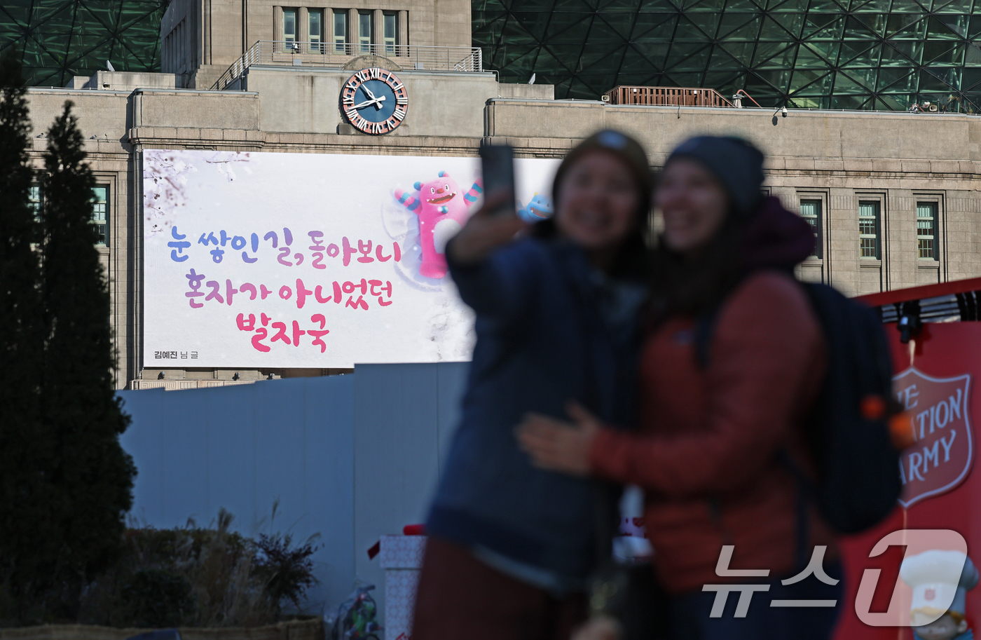 (서울=뉴스1) 오대일 기자 = 3일 서울광장을 찾은 외국인 관광객들이 겨울편으로 새단장한 서울꿈새김판 앞에서 기념촬영을 하고 있다.'겨울의 추위를 잊게 해주는 따뜻하고 희망찬 글 …