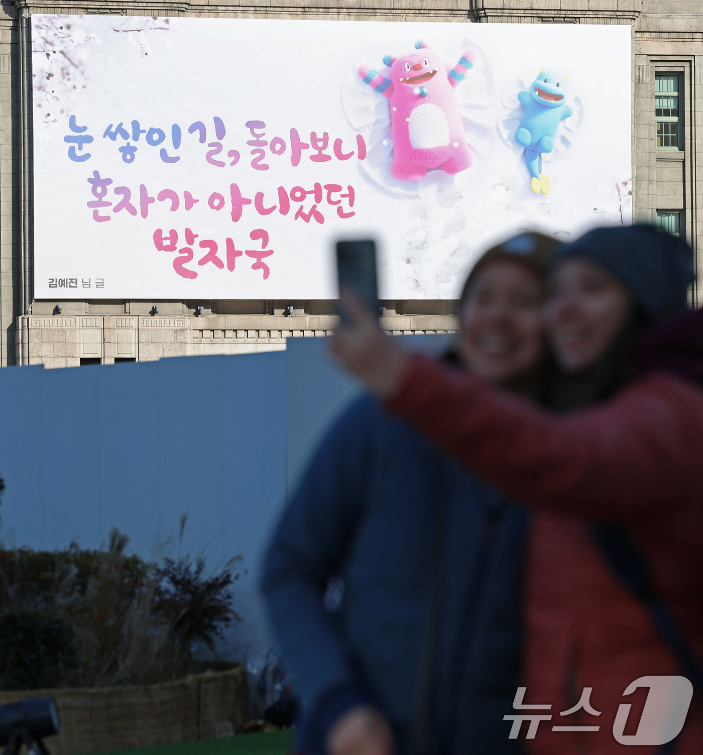 (서울=뉴스1) 오대일 기자 = 3일 서울광장을 찾은 외국인 관광객들이 겨울편으로 새단장한 서울꿈새김판 앞에서 기념촬영을 하고 있다.'겨울의 추위를 잊게 해주는 따뜻하고 희망찬 글 …