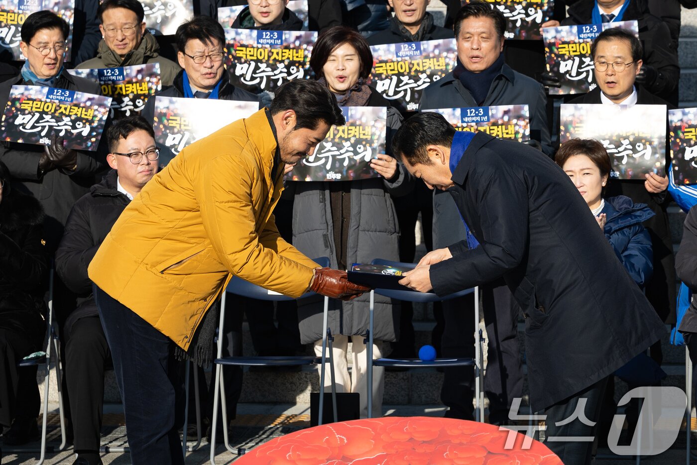 본문 이미지 - 비상계엄 당시 707출신으로 계엄군 설득에 나섰던 배우 이관훈씨가 3일 서울 여의도 국회 본청 앞 계단에서 열린 더불어민주당 12.3 내란 저지 1년 현장 최고위원회의에서 정청래 대표로부터 감사장을 건네받고 있다. 2025.12.3/뉴스1 ⓒ News1 유승관 기자