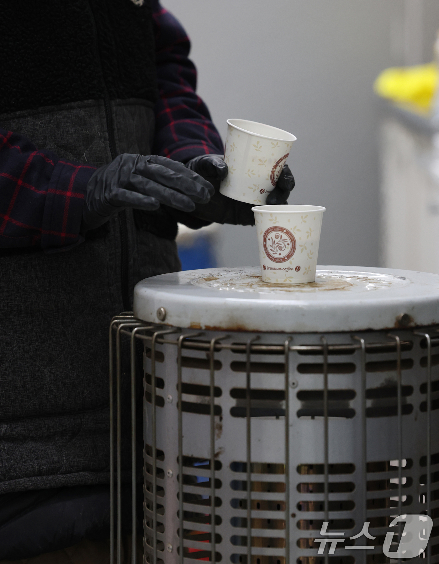 (수원=뉴스1) 김영운 기자 = 올겨울 첫 한파특보가 내려진 3일 경기 수원시 권선구 수원농수산물도매시장 채소동에서 상인들이 가스난로에 몸을 녹이고 있다. 2025.12.3/뉴스1 …