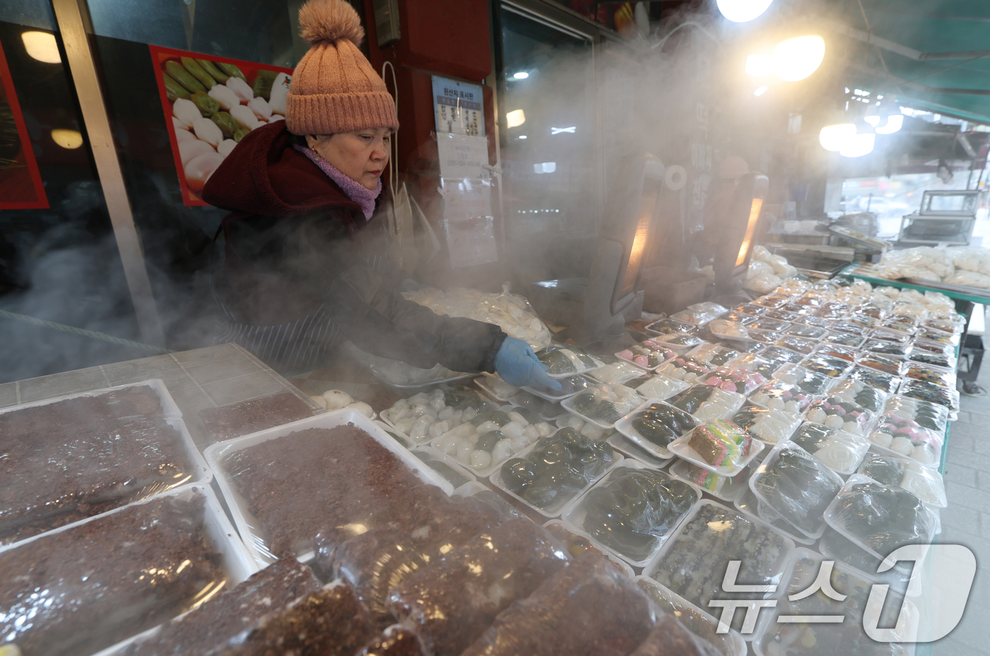 (수원=뉴스1) 김영운 기자 = 올겨울 첫 한파특보가 내려진 3일 경기 수원시 팔달구 수원영동시장 인근 떡집에서 상인들이 갓 나온 떡을 진열하고 있다. 2025.12.3/뉴스1