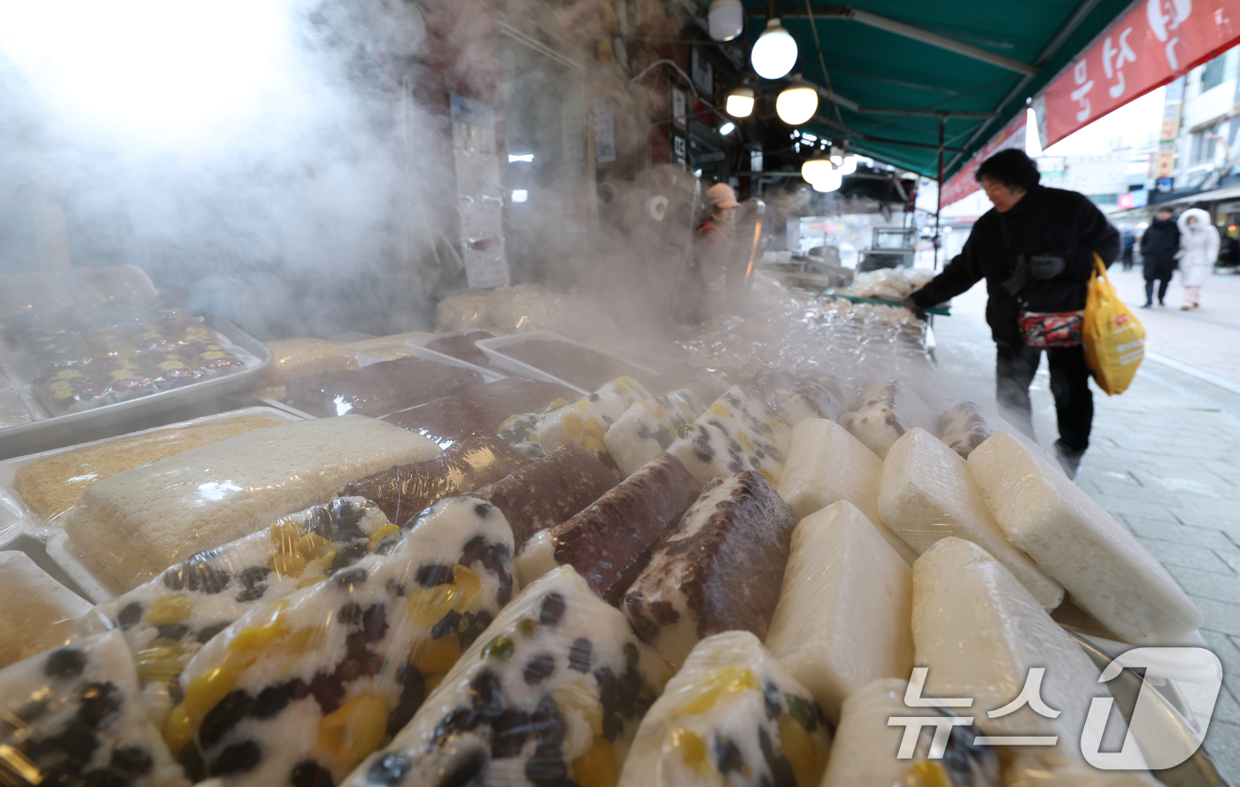 (수원=뉴스1) 김영운 기자 = 올겨울 첫 한파특보가 내려진 3일 경기 수원시 팔달구 수원영동시장 인근 떡집에서 시민들이 떡을 고르고 있다. 2025.12.3/뉴스1