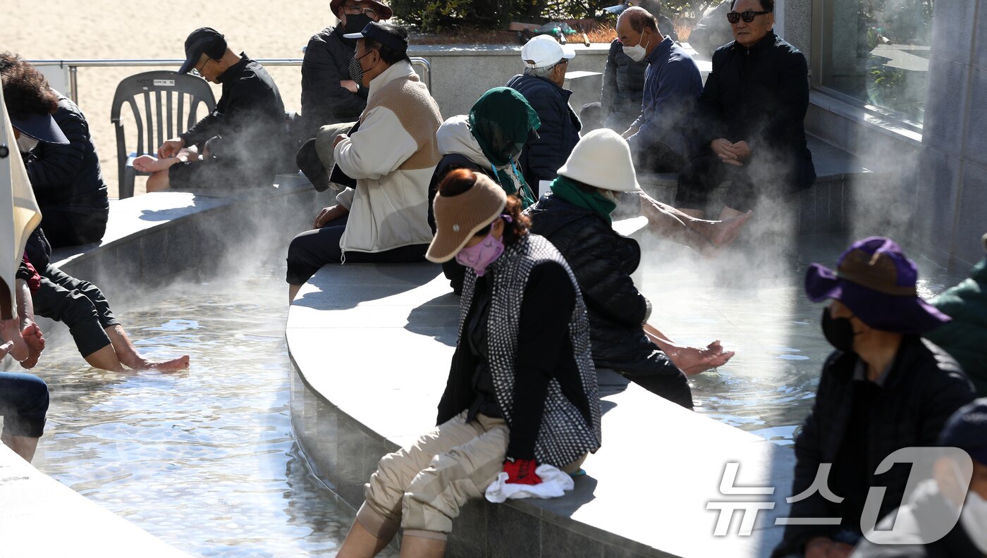 본문 이미지 - 전국적으로 추위가 기승을 부린 3일 부산 해운대해수욕장 온천족욕탕을 찾은 시민들이 따뜻한 온천물에 발을 담그고 추위를 녹이고 있다. 2025.12.3/뉴스1 ⓒ News1 윤일지 기자