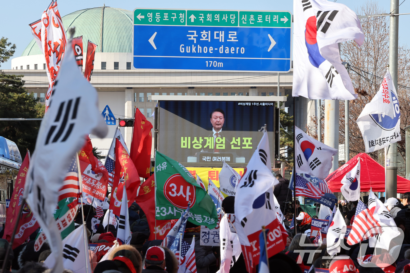 (서울=뉴스1) 황기선 기자 = 12·3 비상계엄 1년을 맞은 3일 오후 서울 영등포구 여의도 국회의사당역 앞에서 신자유연대 등 보수단체 회원들이 윤석열 전 대통령의 계엄 선포 영 …