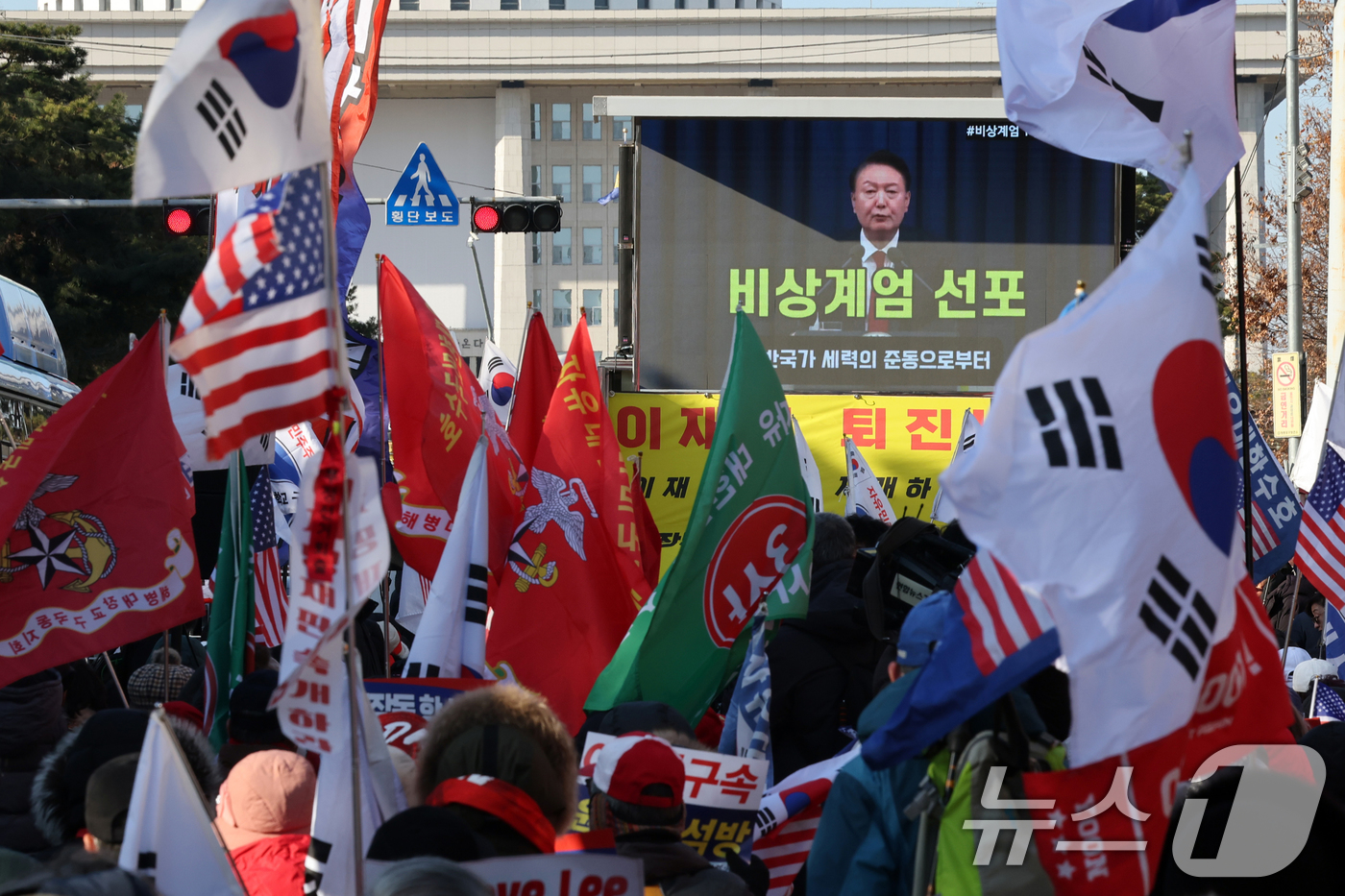 (서울=뉴스1) 황기선 기자 = 12·3 비상계엄 1년을 맞은 3일 오후 서울 영등포구 여의도 국회의사당역 앞에서 신자유연대 등 보수단체 회원들이 윤석열 전 대통령의 계엄 선포 영 …
