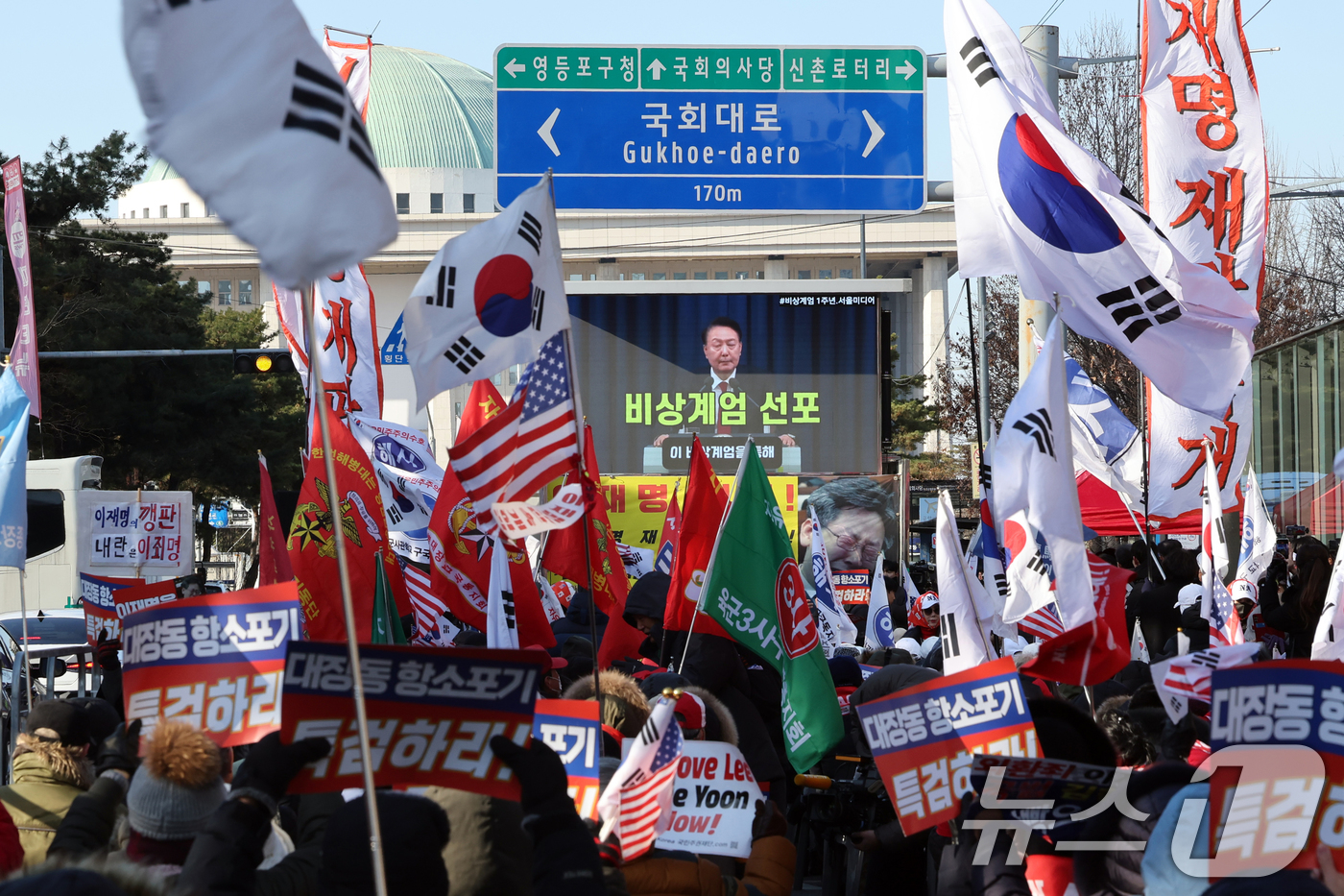(서울=뉴스1) 황기선 기자 = 12·3 비상계엄 1년을 맞은 3일 오후 서울 영등포구 여의도 국회의사당역 앞에서 신자유연대 등 보수단체 회원들이 윤석열 전 대통령의 계엄 선포 영 …