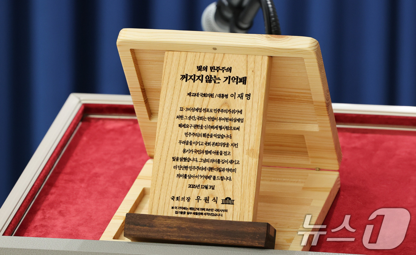 (서울=뉴스1) 허경 기자 = 3일 서울 용산 대통령실 청사에서 열린 5부 요인 초청 오찬 관련 브리핑에서 '빛의 민주주의 꺼지지 않는 기억패'가 공개되고 있다.이재명 대통령은 이 …