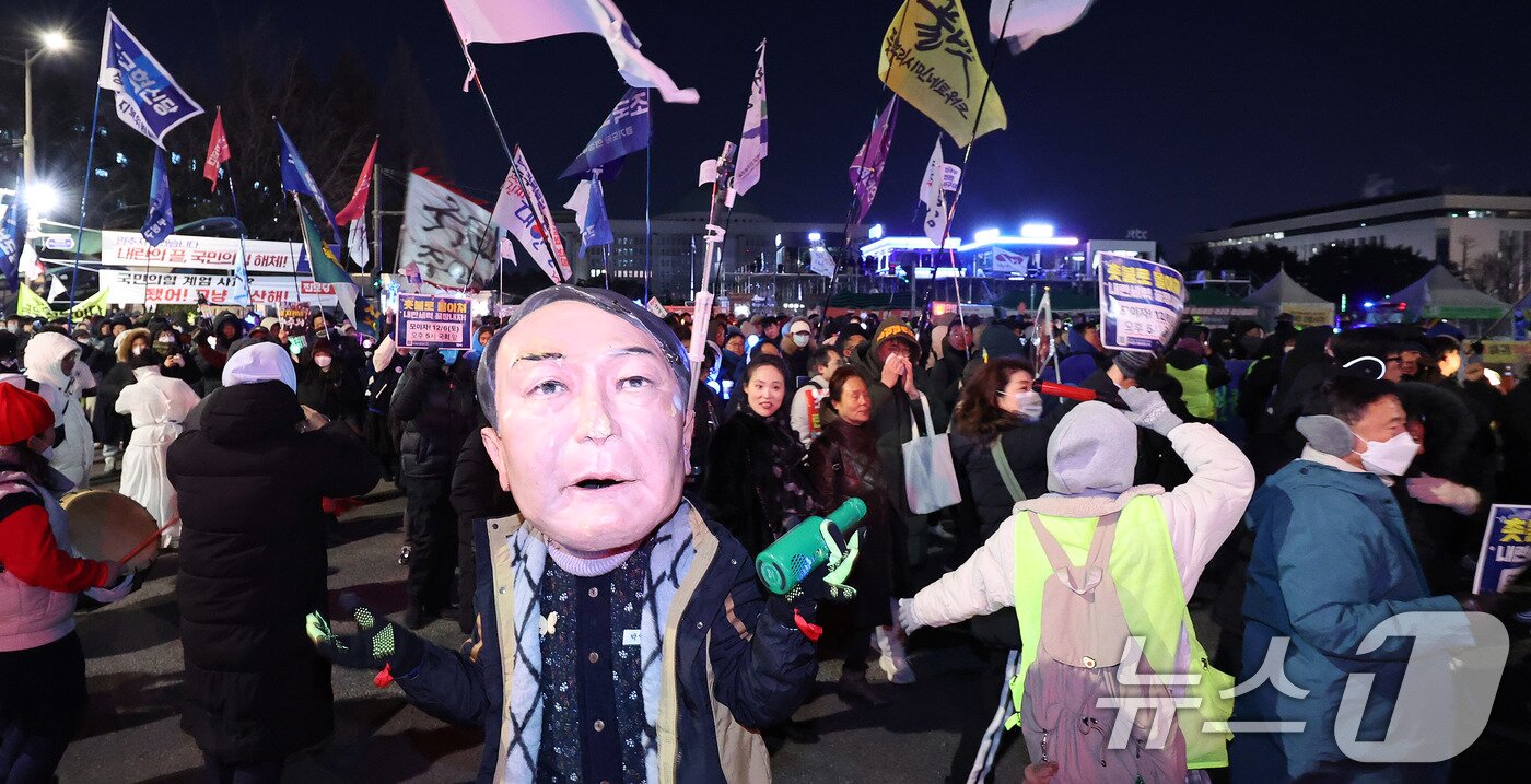 본문 이미지 - 12·3 비상계엄 1년을 맞은 3일 서울 여의도 국회 앞에서 열린 &#39;12·3 내란외환 청산과 종식, 사회대개혁 시민대행진&#39;에서 윤석열 전 대통령 가면을 쓴 시민이 행진하고 있다. 2025.12.3/뉴스1 ⓒ News1 박지혜 기자