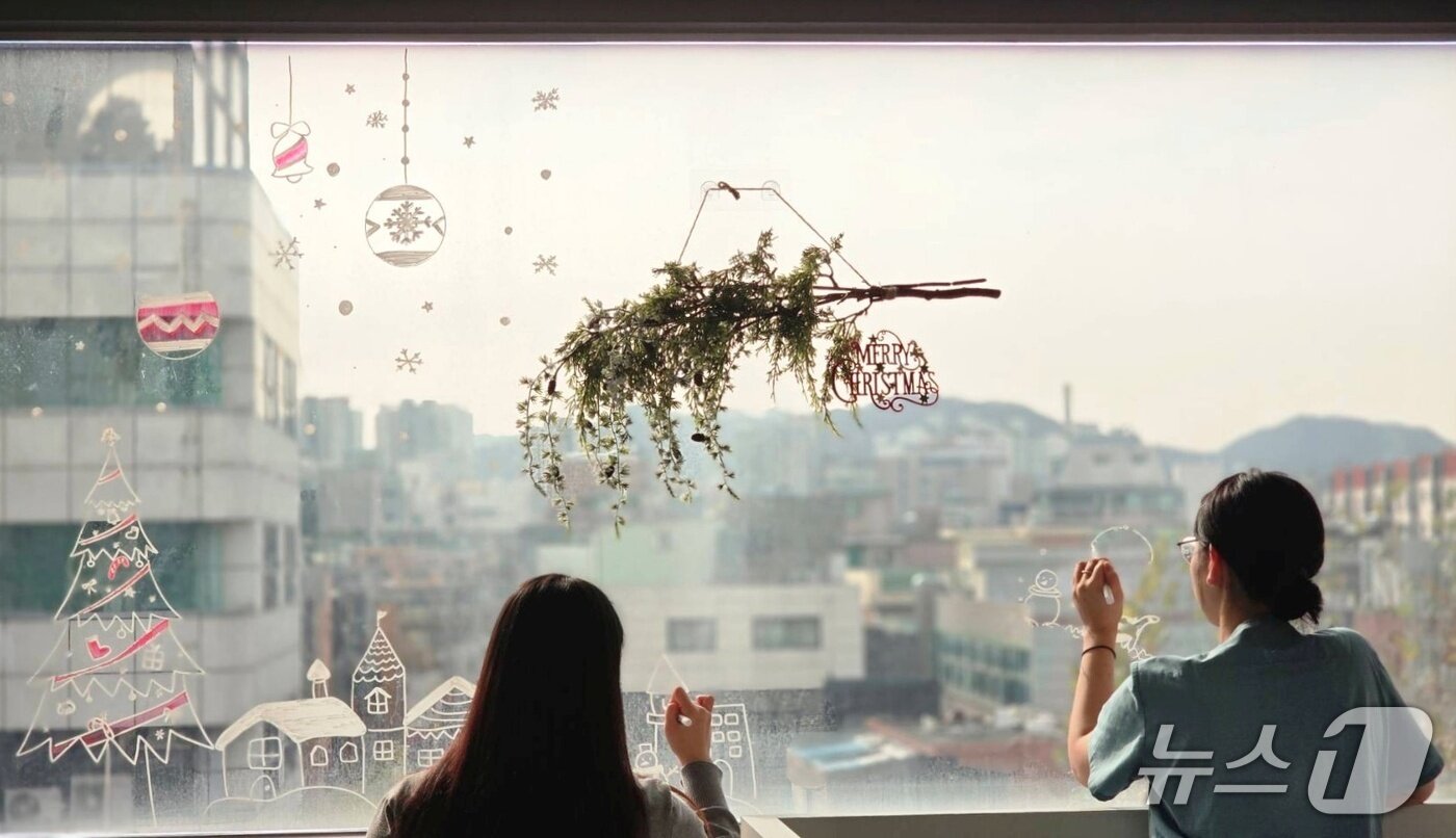 본문 이미지 - 샤인 고양이메디컬센터 직원들이 특수 펜으로 창문에 연말 그림을 그리고 있다(병원 제공). ⓒ 뉴스1