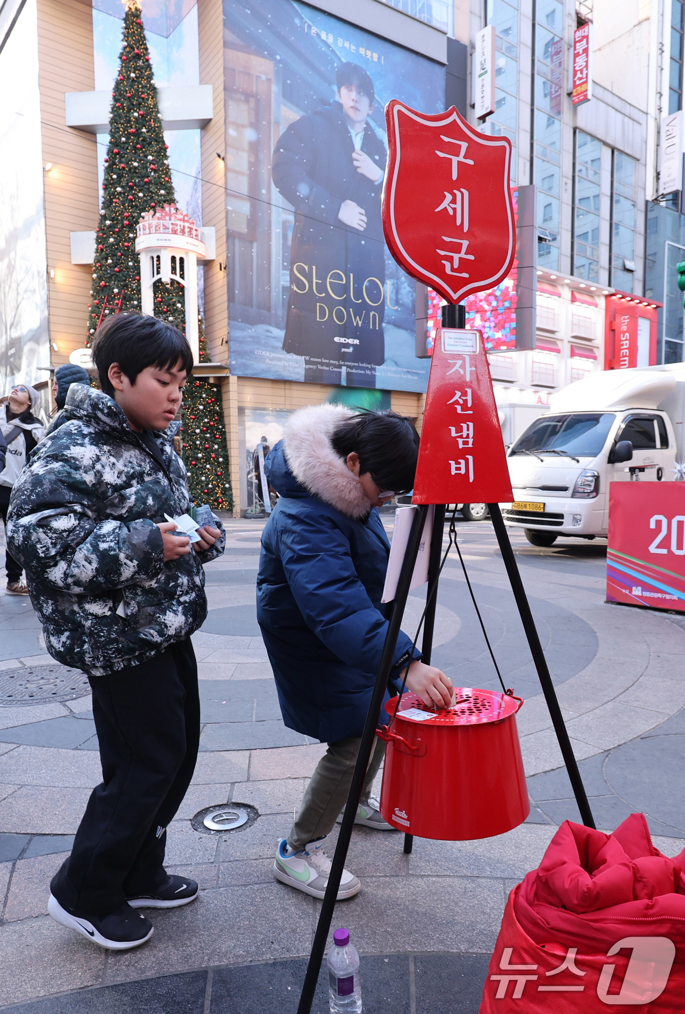 (서울=뉴스1) 박지혜 기자 = 자선냄비 모금 행사 종료를 하루 앞둔 30일 서울 중구 명동거리에서 어린이들이 자선냄비에 기부하고 있다.구세군 자선냄비 모금 행사는 오는 31일까지 …