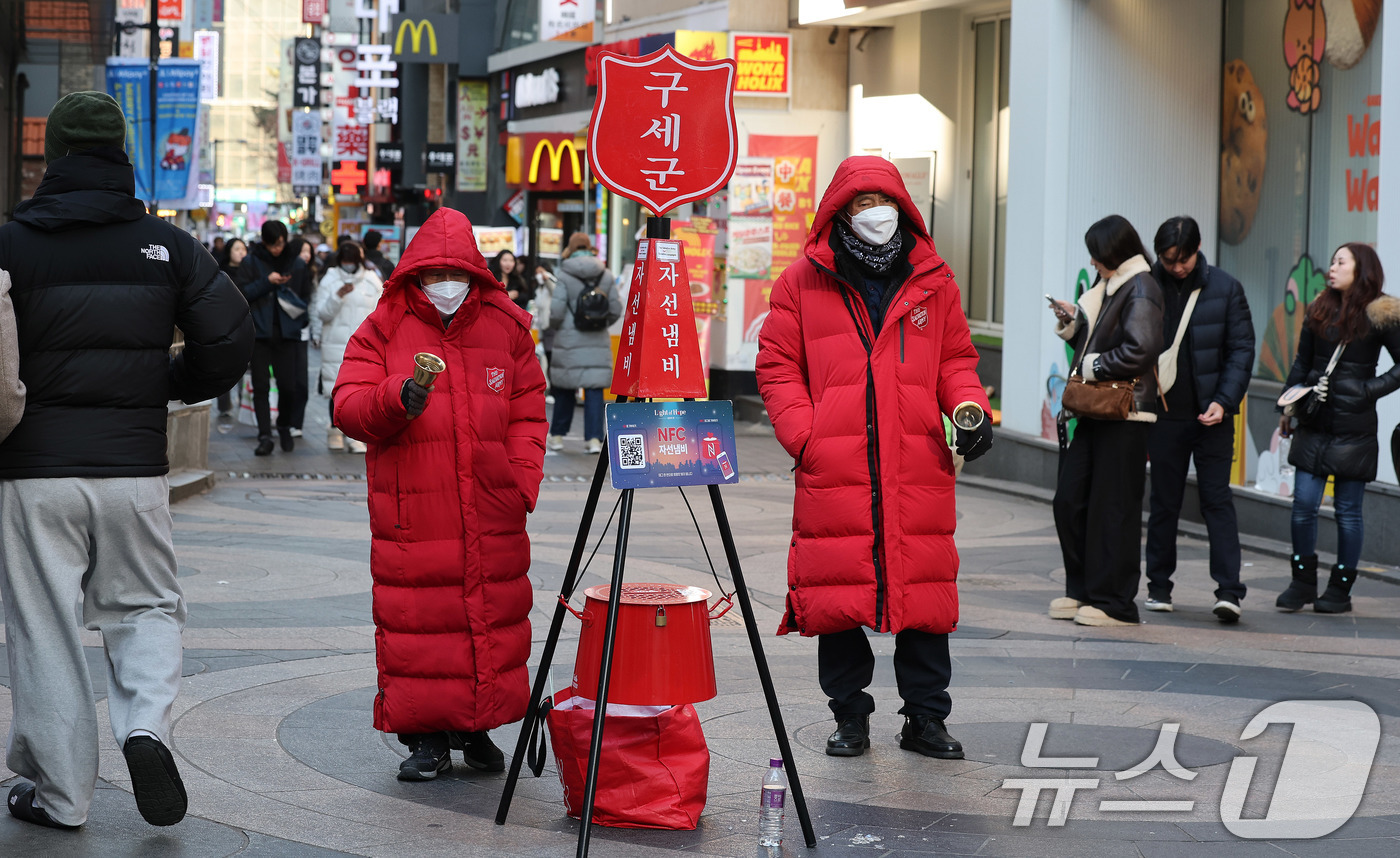 (서울=뉴스1) 박지혜 기자 = 자선냄비 모금 행사 종료를 하루 앞둔 30일 서울 중구 명동거리 자선냄비 앞에서 캐틀메이트가 종을 울리고 있다.캐틀메이트란 구세군 자선냄비 앞에서 …