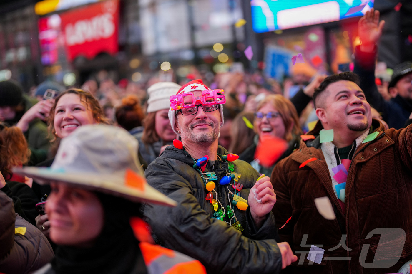 (뉴욕 로이터=뉴스1) 이정환 기자 = 29일(현지시간) 미국 뉴욕 타임스퀘어에서 새해맞이 볼 드롭 행사를 준비하는 관계자들이 색종이 조각 테스트를 하는 동안, 2026년 안경을 …