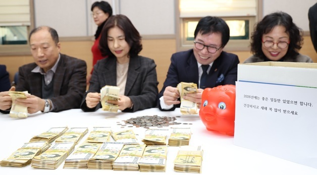 얼굴없는천사가 보내온 성금 확인하는 직원들