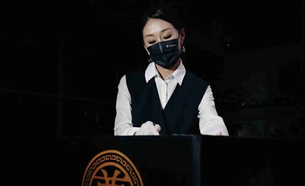 본문 이미지 -  판 씨가 죽은 사람에게 바를 화장품을 조심스럽게 준비하는 모습. (더우인)