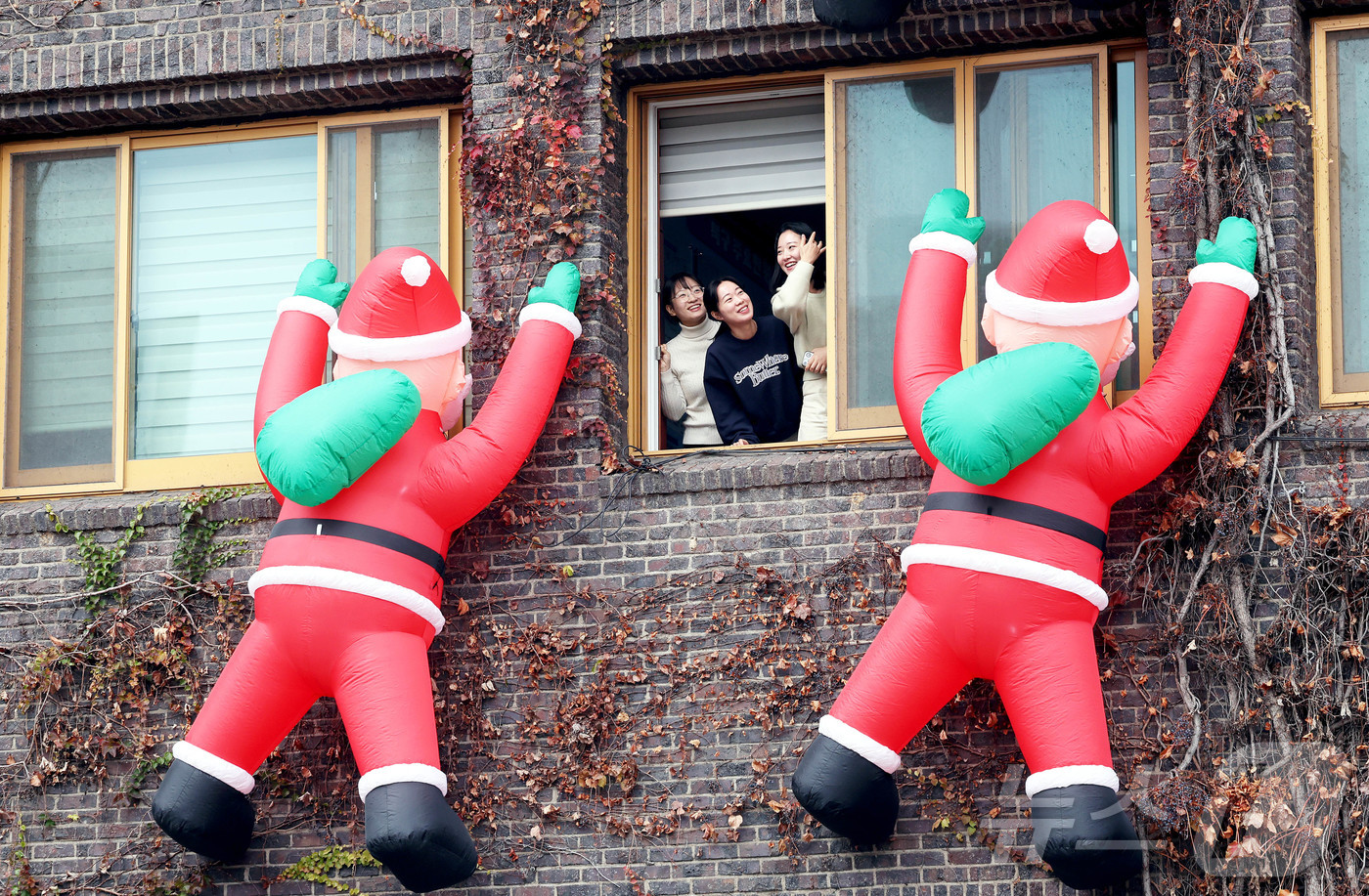 (광주=뉴스1) 박지현 기자 = 4일 광주 북구청에 산타클로스 인형이 설치됐다. 청사 외벽을 타고 오르는 모습이다. 사람들이 인형을 보며 즐거워하고 있다.(광주 북구 제공. 재판매 …