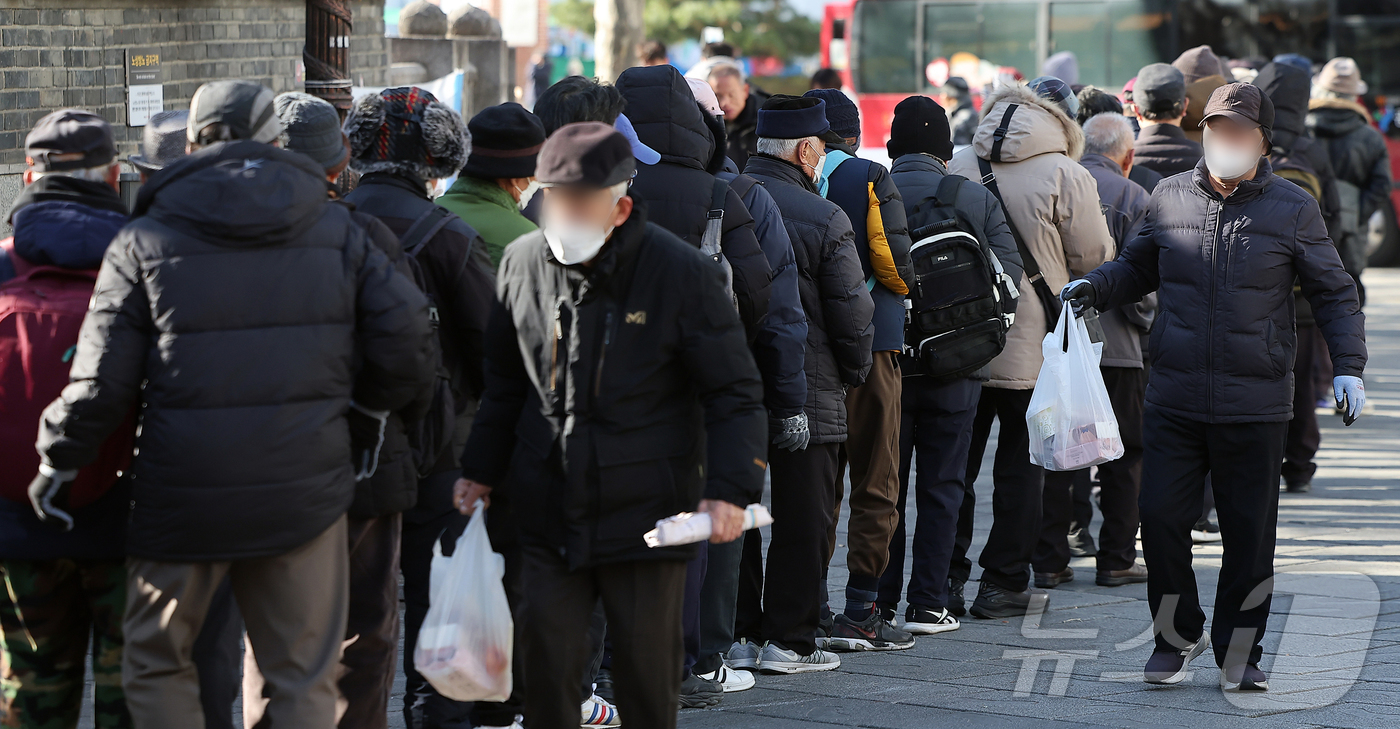 (서울=뉴스1) 김진환 기자 = 서울의 최저기온이 영하 10도 가까이 떨어지며 추운 날씨를 보인 4일 서울 종로구 탑골공원에서 어르신들이 한 종교단체에서 지급하는 간식을 받기 위해 …