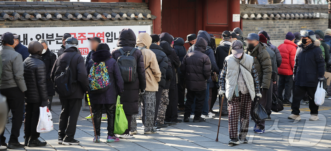 (서울=뉴스1) 김진환 기자 = 서울의 최저기온이 영하 10도 가까이 떨어지며 추운 날씨를 보인 4일 서울 종로구 탑골공원에서 어르신들이 한 종교단체에서 지급하는 간식을 받기 위해 …