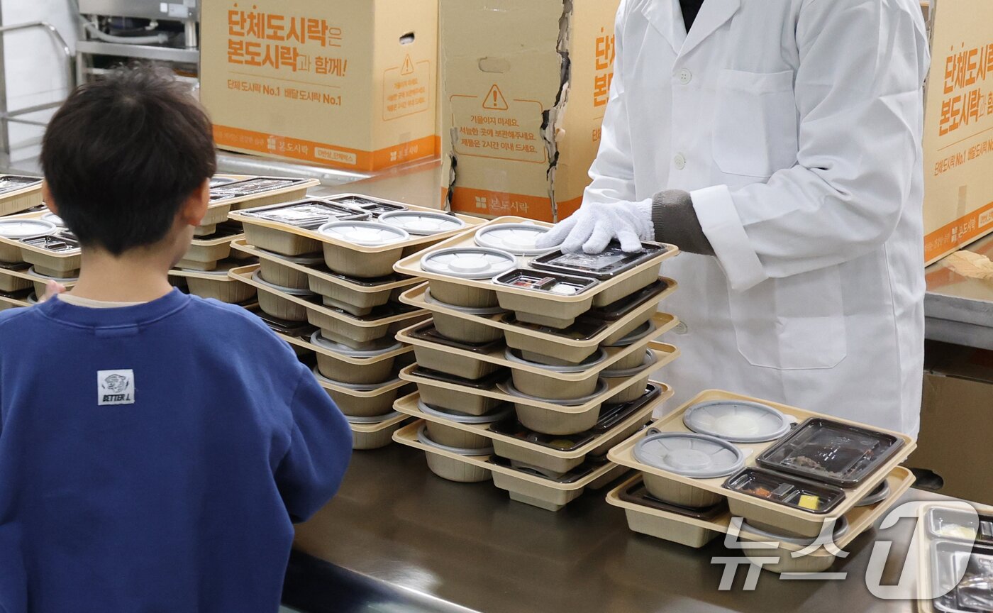 본문 이미지 - 학교 급식·돌봄 업무 등에 종사하는 비정규직 노동자들이 총파업에 돌입한 4일 대전의 한 초등학교에서 어린이들이 도시락을 받고 있다. 2025.12.4/뉴스1 ⓒ News1 김기태 기자