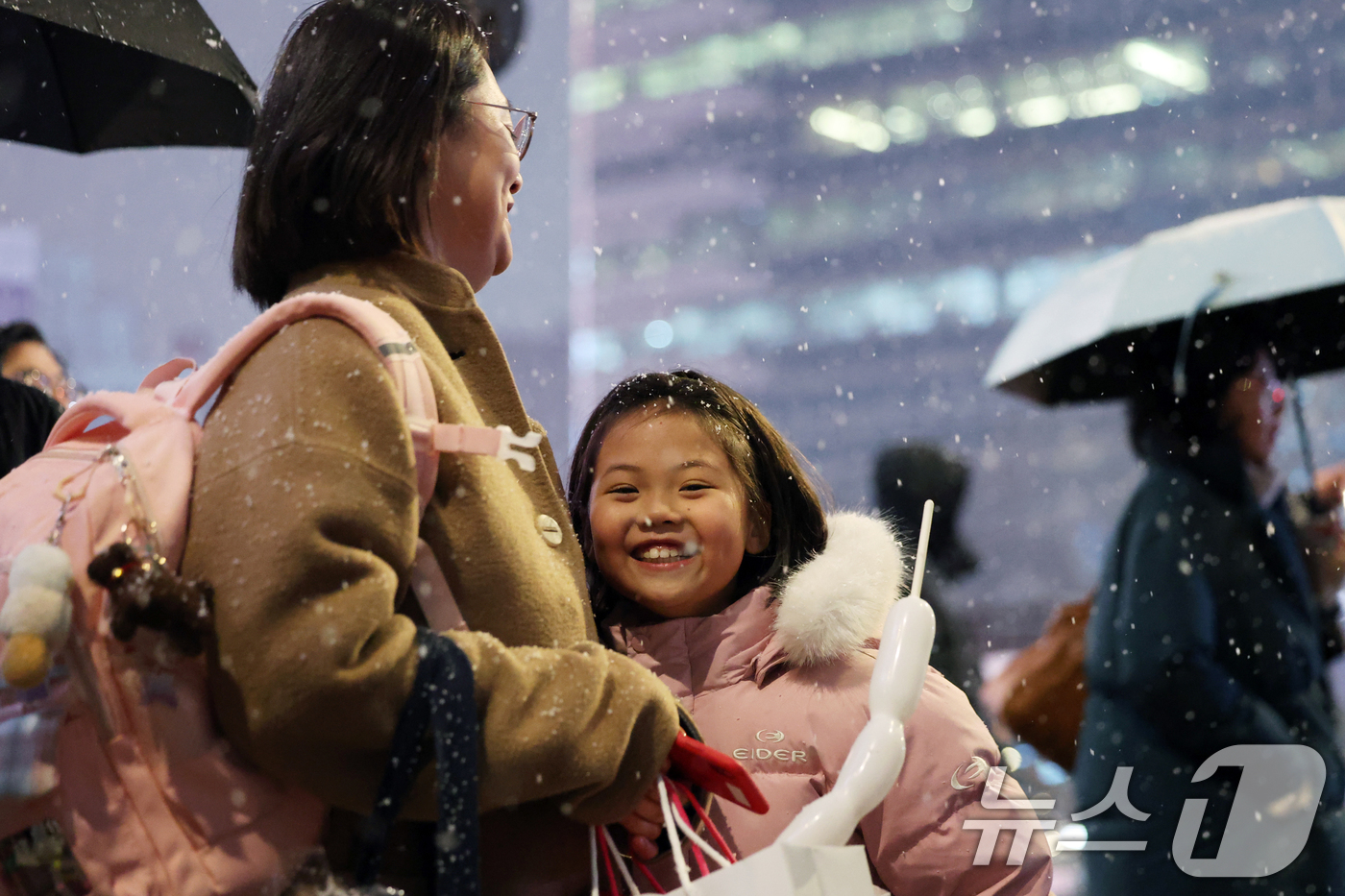 (서울=뉴스1) 황기선 기자 = 첫눈이 내린 4일 오후 서울 광화문 네거리에서 어린이가 미소를 보이며 발걸음을 옮기고 있다.  2025.12.4/뉴스1