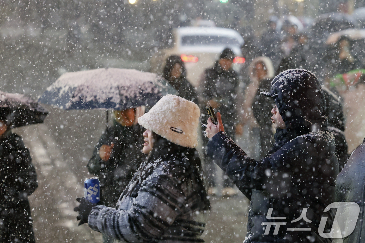 (서울=뉴스1) 박정호 기자 = 첫눈이 내린 4일 오후 서울 중구 명동을 찾은 관광객들이 내리는 눈을 맞으며 즐거운 시간을 보내고 있다.기상청은 "퇴근 시간대 강한 눈이 내릴 가능 …