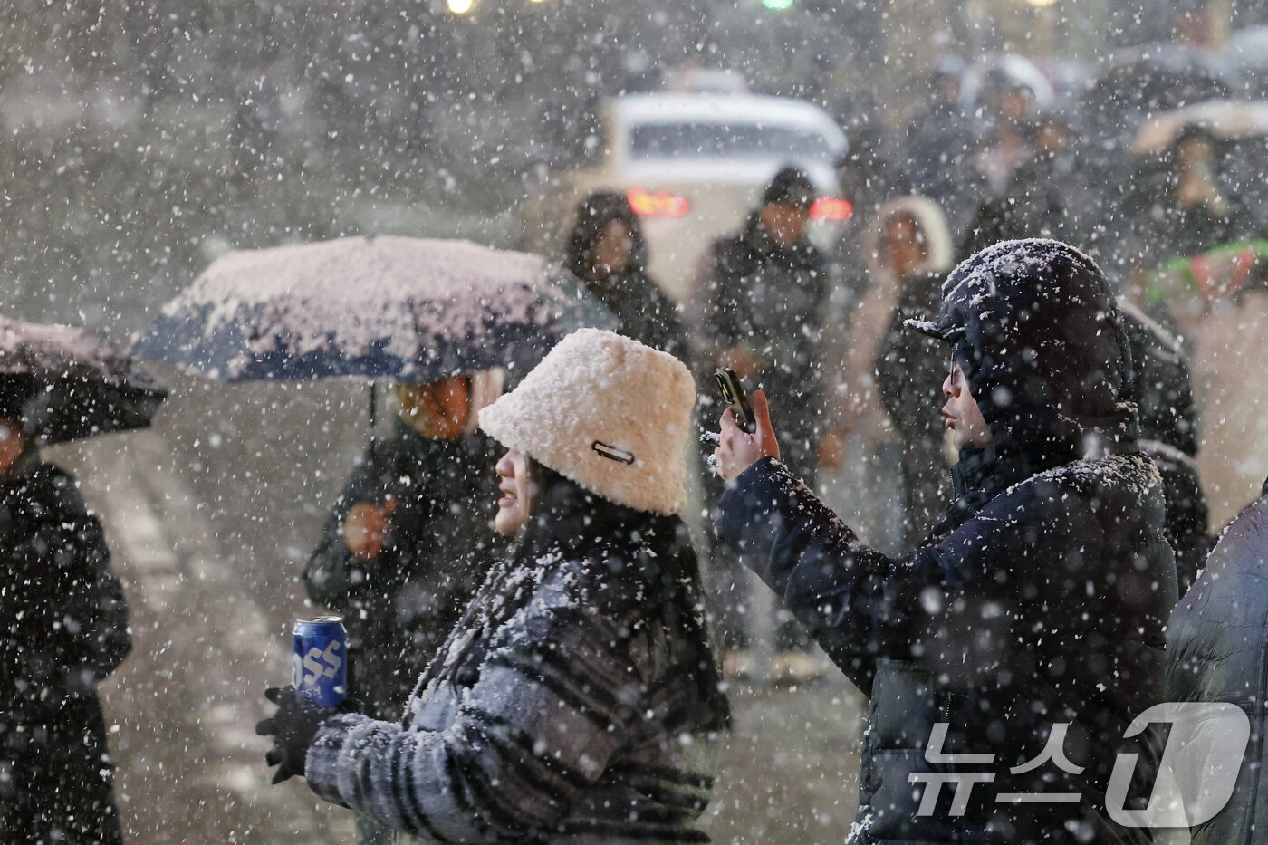 본문 이미지 - 첫눈이 내린 4일 오후 서울 중구 명동을 찾은 관광객들이 내리는 눈을 맞으며 즐거운 시간을 보내고 있다. 기상청은 &#34;퇴근 시간대 강한 눈이 내릴 가능성이 크다＂며 동네 예보와 실시간 날씨를 확인할 것을 당부했다. 2025.12.4/뉴스1 ⓒ News1 박정호 기자