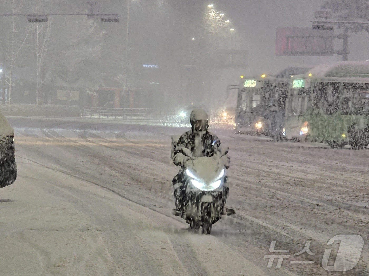 (서울=뉴스1) 황덕현 기후환경전문기자 = 서울 전역에 대설특보가 발령된 4일 오후 서울 중구 서울역 앞 도로에서 배달 오토바이가 거북이 운행을 하고 있다. 2025.12.4/뉴스 …