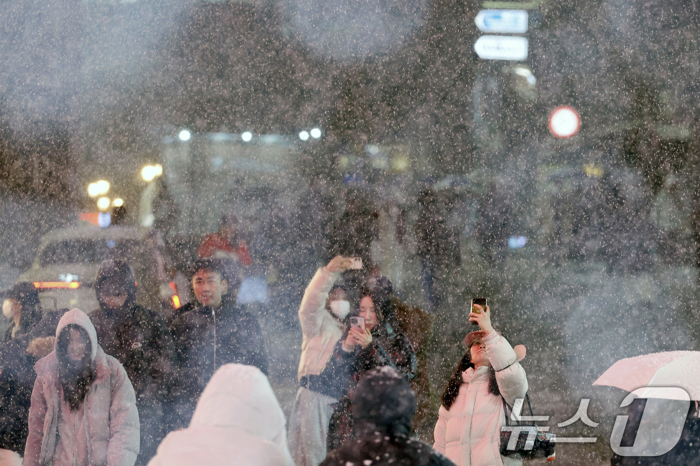 (서울=뉴스1) 박정호 기자 = 첫눈이 내린 4일 오후 서울 중구 명동을 찾은 관광객들이 내리는 눈을 맞으며 거리를 걷고 있다.기상청은 "퇴근 시간대 강한 눈이 내릴 가능성이 크다 …