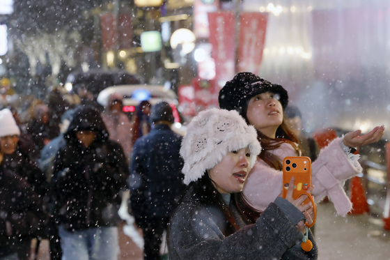 서울에서 만난 첫눈이 즐거운 관광객들