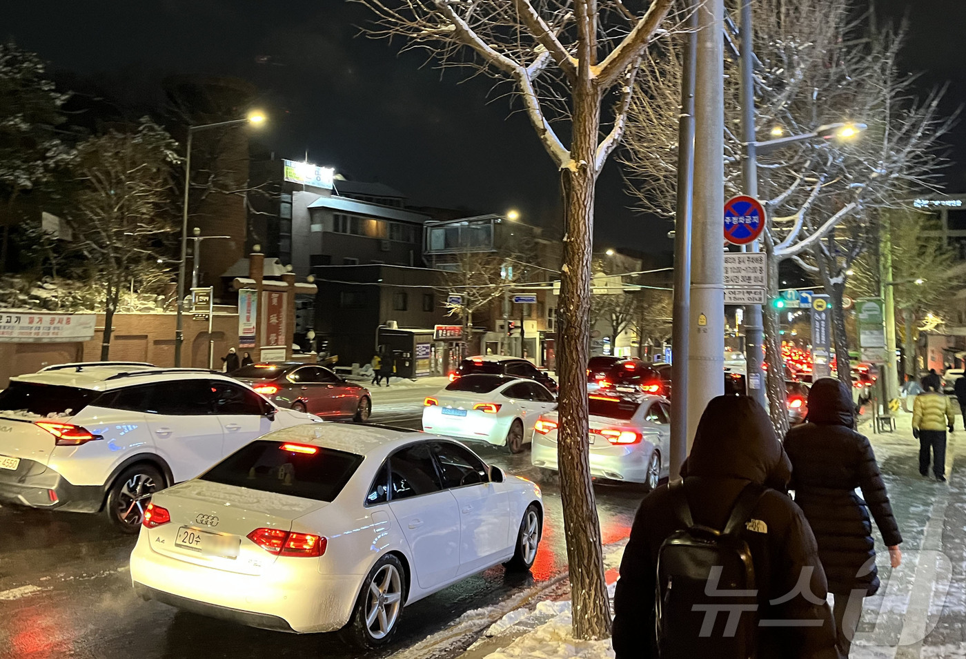 (서울=뉴스1) 황기선 기자 = 폭설이 내린 4일 오후 서울 종로구 자하문로에서 차량들이 눈길에 큰 정체를 빚자 시민들이 버스에서 내려 걸어가고 있다. 2025.12.4/뉴스1