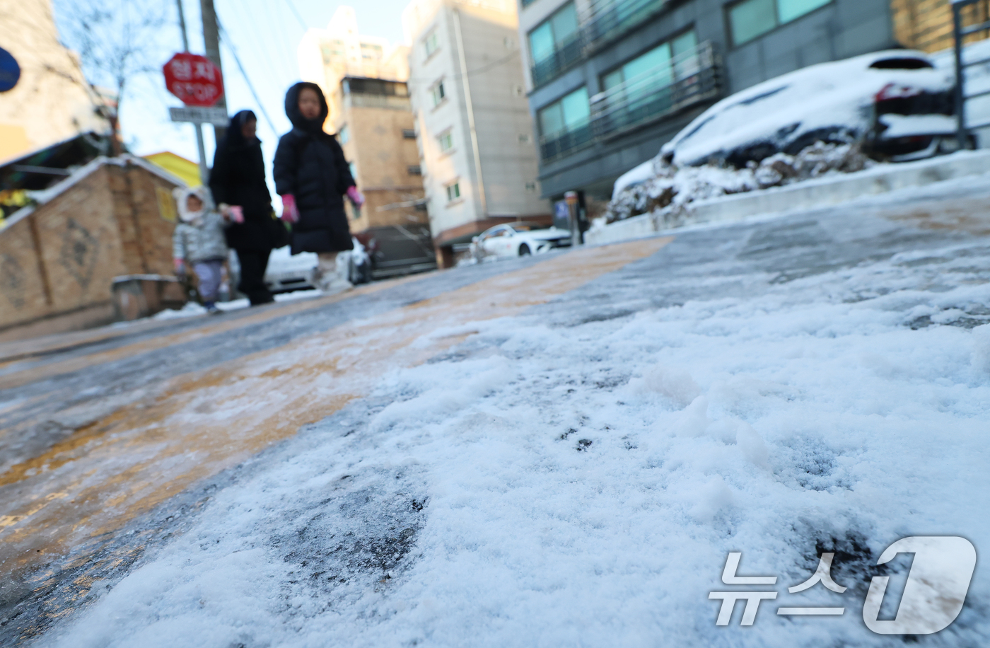 (서울=뉴스1) 오대일 기자 = 폭설 후 한파로 도로 곳곳이 얼어 붙은 5일 오전 서울 광진구에서 한 여성이 아이들과 빙판길을 걷고 있다.  2025.12.5/뉴스1