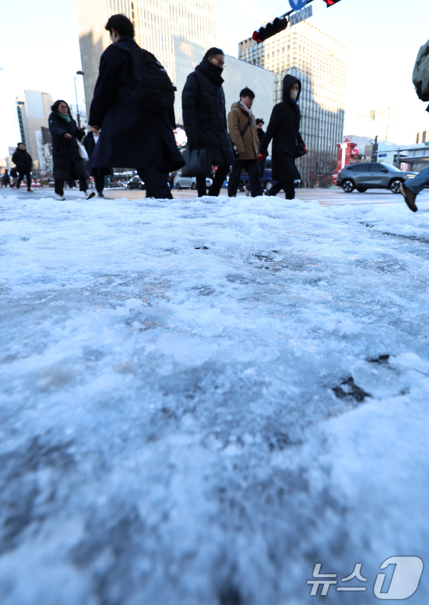 (서울=뉴스1) 구윤성 기자 = 폭설 후 한파로 도로 곳곳이 얼어붙은 5일 오전 서울 광화문역 일대에서 시민들이 출근길 발걸음을 옮기고 있다. 2025.12.5/뉴스1