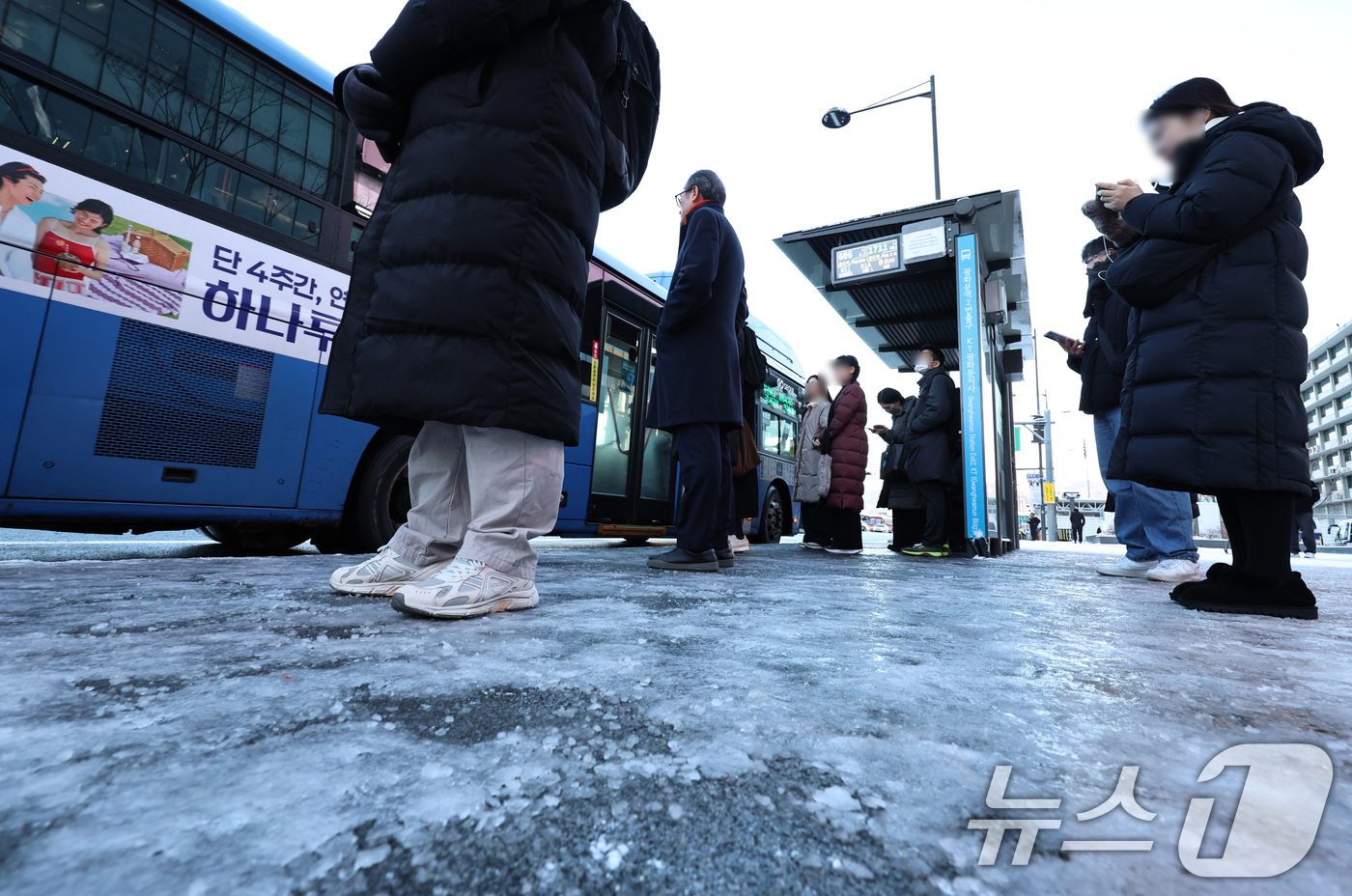 (서울=뉴스1) 구윤성 기자 = 폭설 후 한파로 도로 곳곳이 얼어붙은 5일 오전 서울 광화문 일대에서 시민들이 버스를 기다리고 있다.서울시는 이날 출근 시간대 지하철·버스 출퇴근 …