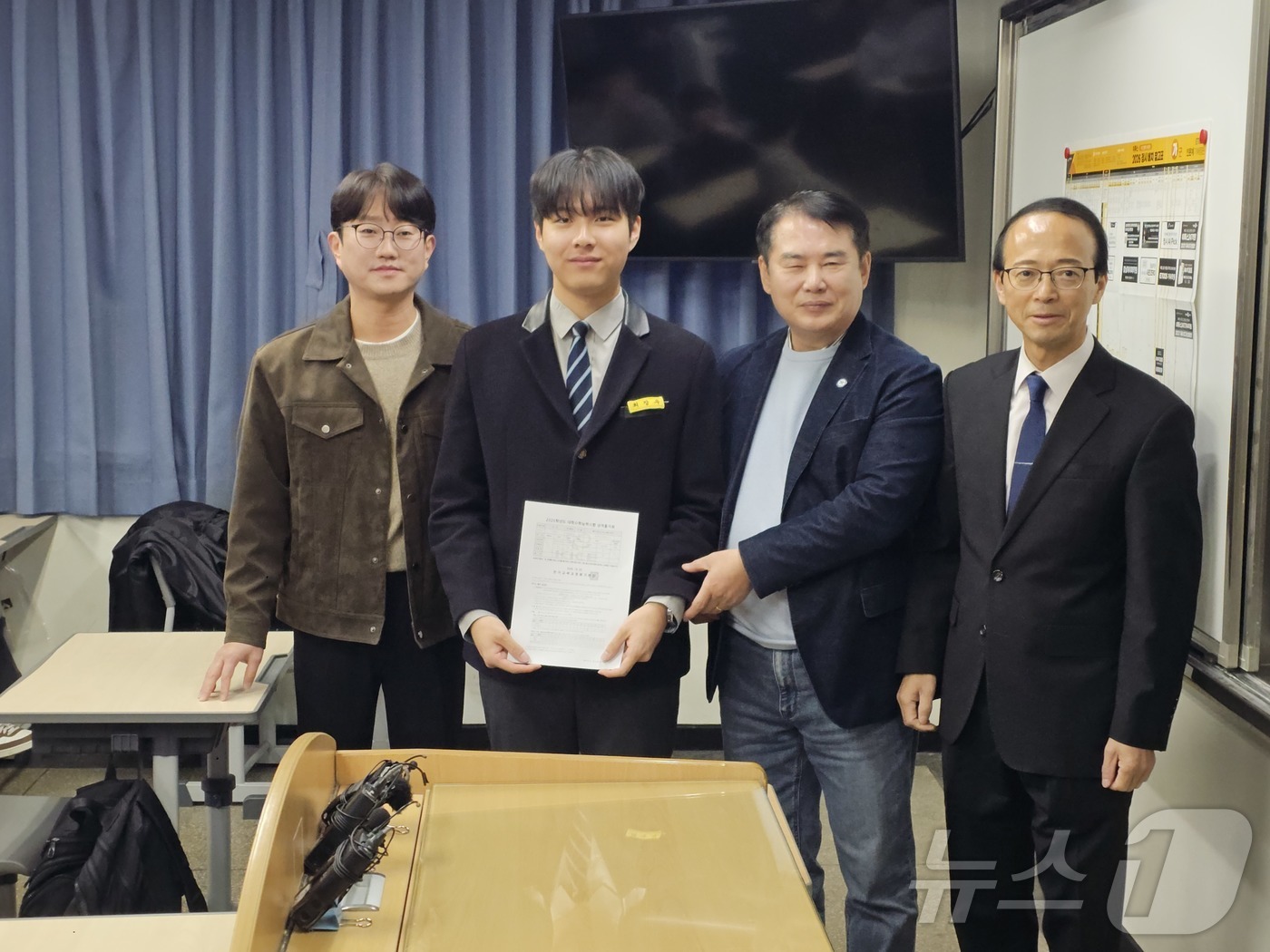 (광주=뉴스1) 서충섭 기자 = 이정선 광주교육감이 5일 오전 서석고에서 광주 수능 만점자 최장우군에 성적통지표를 전달하고 있다. 2025.12.5/뉴스1