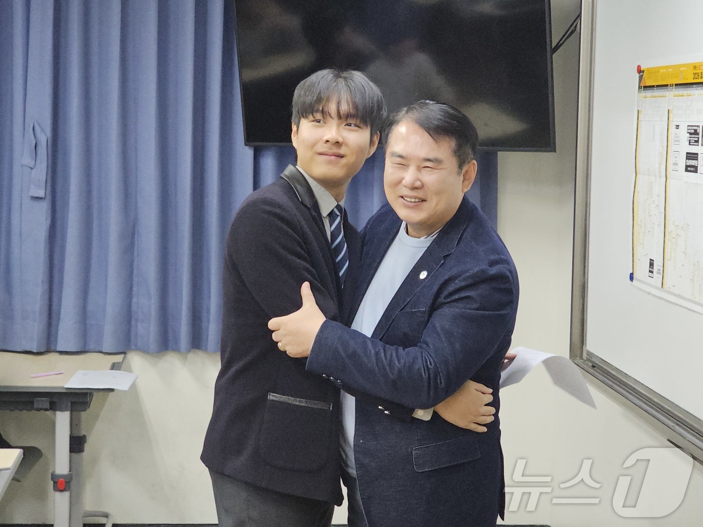 (광주=뉴스1) 서충섭 기자 = 이정선 광주교육감이 5일 오전 서석고에서 광주 수능 만점자 최장우군에 성적통지표를 전달하고 포옹하고 있다. 2025.12.5/뉴스1