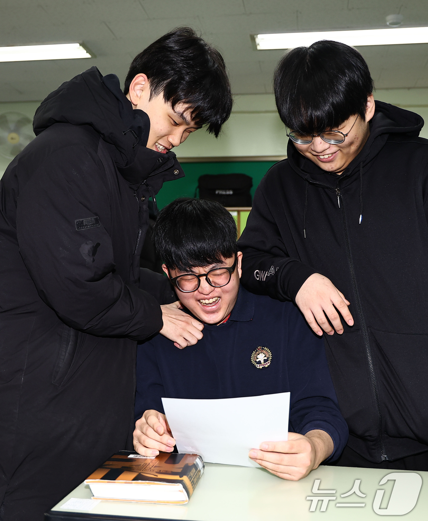(서울=뉴스1) 오대일 기자 = 2025학년도 대학수학능력시험 성적표가 배부된 5일 오전 서울 광진구 광남고등학교에서 '수능 만점자' 왕정건 학생이 성적표를 확인하며 친구들의 축하 …