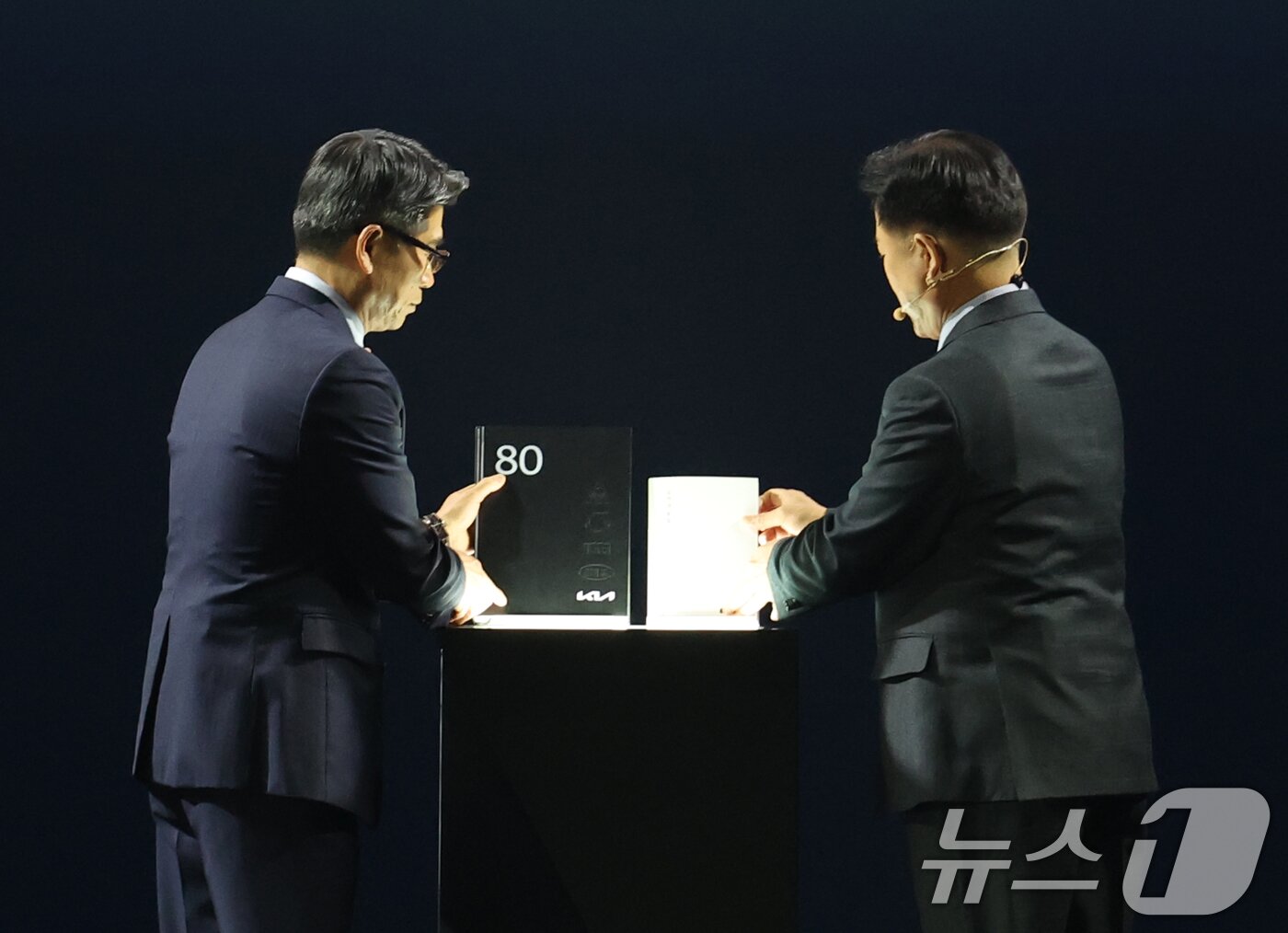 본문 이미지 - 송호성 기아 대표이사 사장과 정의철 기아 기업전략실 전무가 5일 경기 용인시 처인구 기아 비전스퀘어에서 열린 &#39;기아 80주년 기념식&#39;에서 기아 80년 사사를 공개하고 있다. 2025.12.5/뉴스1 ⓒ News1 김영운 기자