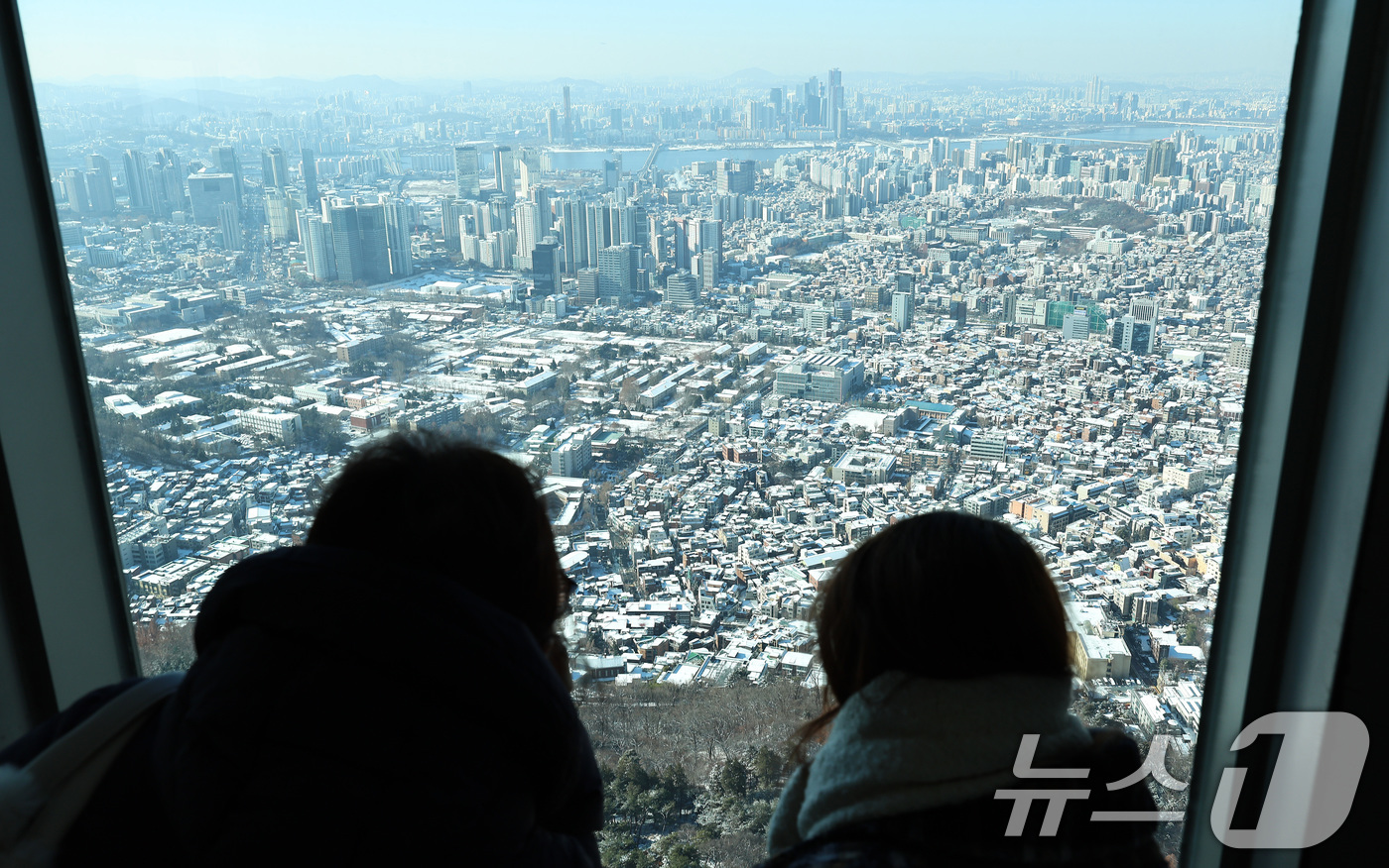 (서울=뉴스1) 구윤성 기자 = 5일 오전 남산 서울타워를 찾은 외국인 관광객들이 눈 내린 시내를 내려다보고 있다. 2025.12.5/뉴스1