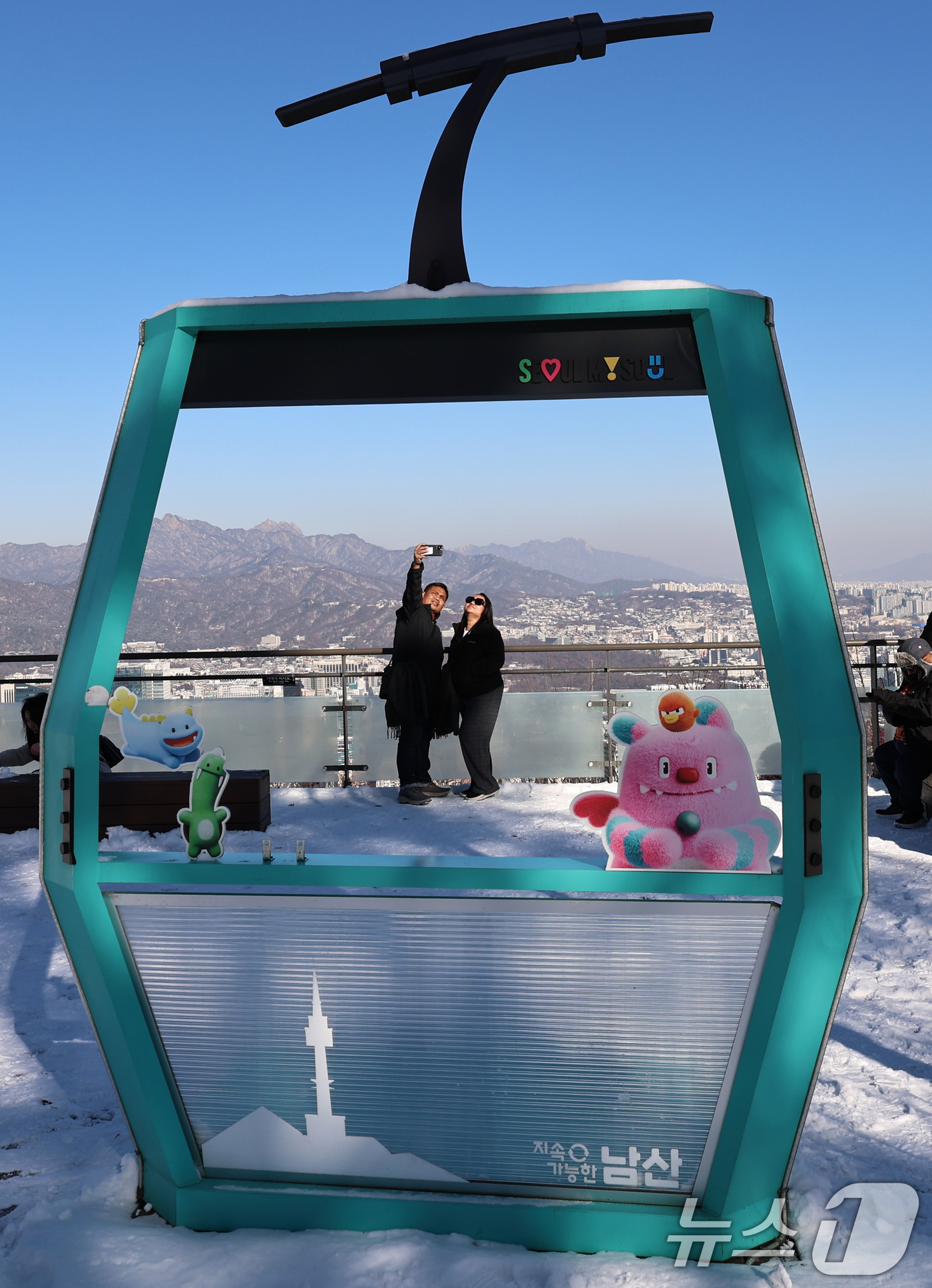 (서울=뉴스1) 구윤성 기자 = 5일 오전 서울 남산을 찾은 외국인 관광객들이 전날 내린 눈을 배경으로 스마트폰 셀카를 찍고 있다. 2025.12.5/뉴스1