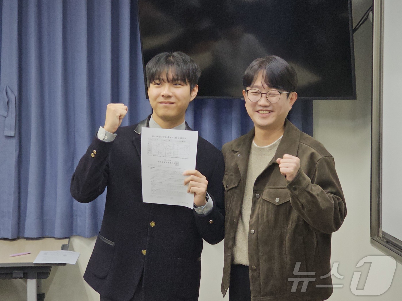 (광주=뉴스1) 서충섭 기자 = 2026학년도 광주 수능 만점자인 최장우군이 5일 서석고에서 수능 성적 통지서를 받아들고 담임인 정승균 교사와 활짝 웃고 있다. 2025.12.5/ …