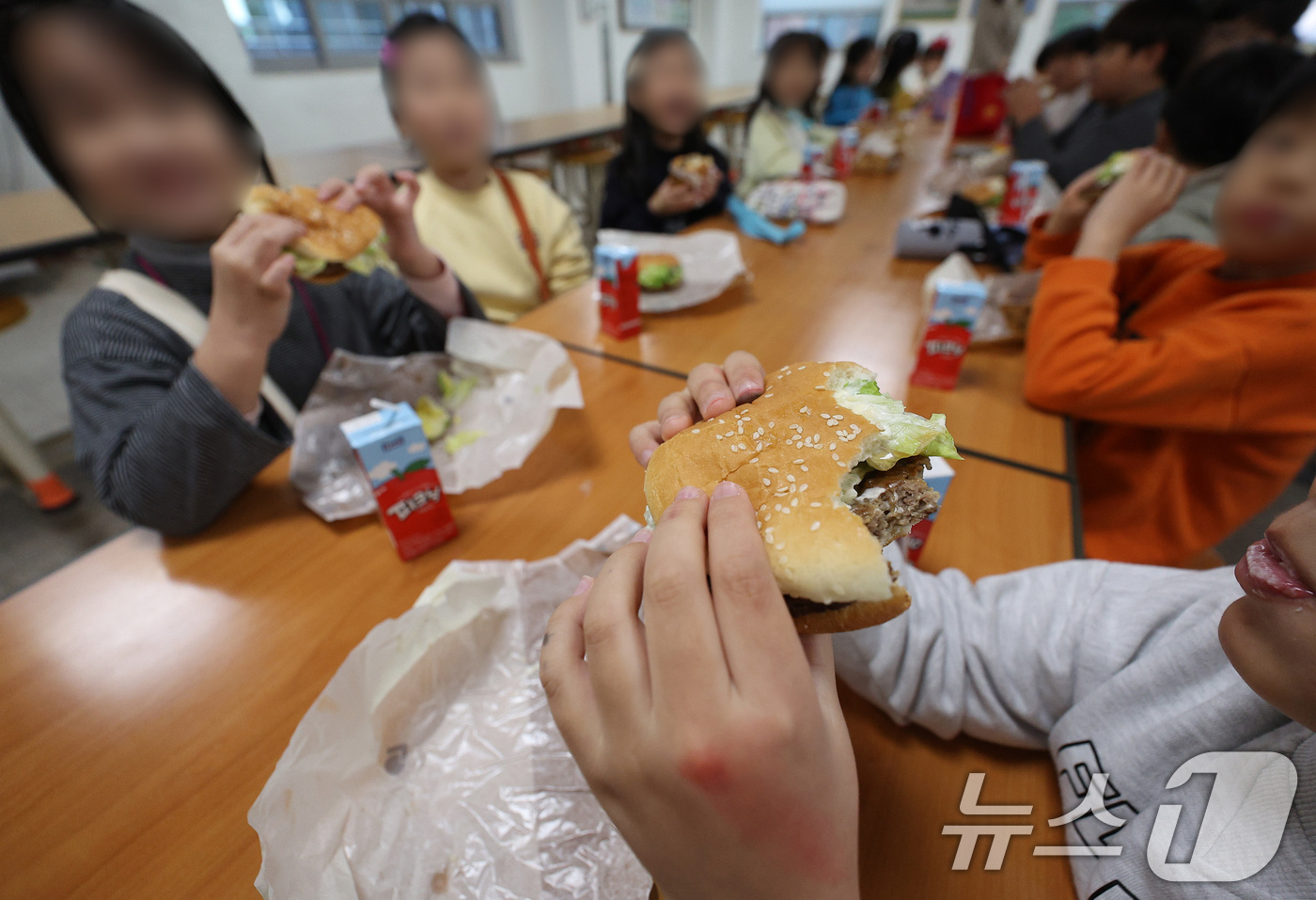 (대구=뉴스1) 공정식 기자 = 전국학교비정규직연대회의가 파업에 들어간 5일 대구의 한 초등학교 급식실에서 학생들이 대체식으로 제공된 햄버거를 먹고 있다. 2025.12.5/뉴스1 …