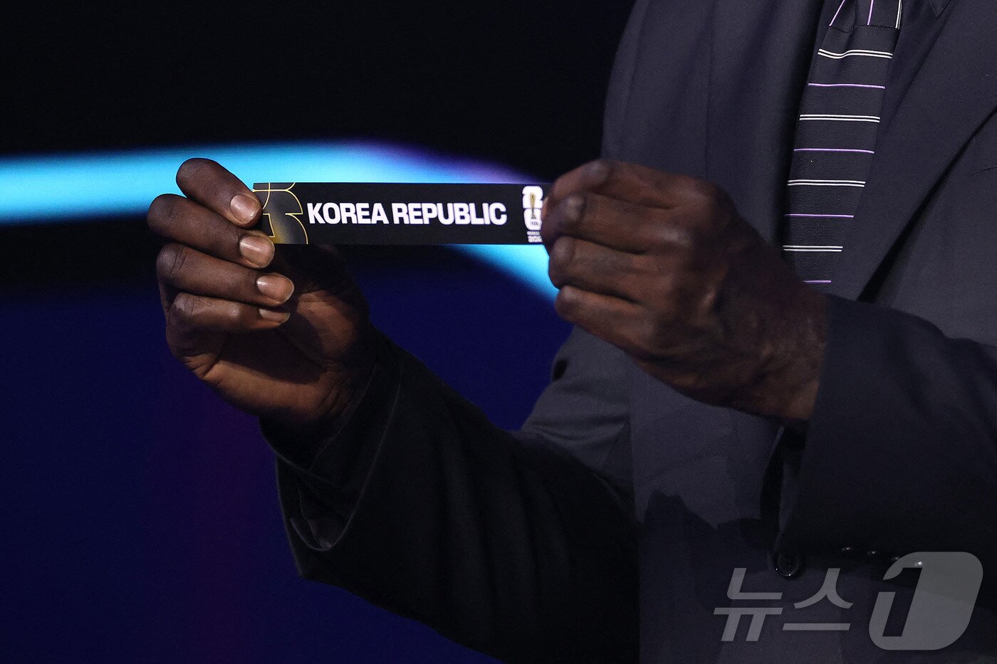 본문 이미지 - 5일&#40;현지시간&#41; 미국 워싱턴DC 케네디센터에서 열린 2026 북중미 월드컵 조 추첨식에서 샤킬 오닐이 대한민국 카드를 뽑고 있다. 한국은 개최국 멕시코, 남아프리카공화국, 유럽 플레이오프 D조&#40;덴마크, 북마케도니아, 체코, 아일랜드 승자&#41;와 함께 A조에서 32강 진출을 두고 격돌한다. ⓒ AFP=뉴스1