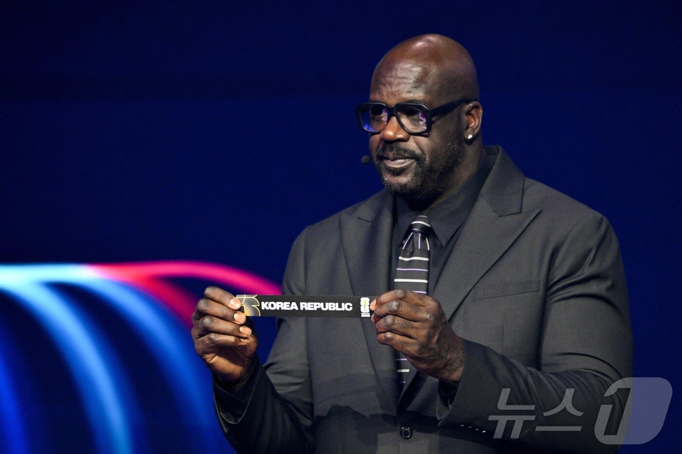 본문 이미지 - 5일&#40;현지시간&#41; 미국 워싱턴DC 케네디센터에서 열린 2026 북중미 월드컵 조 추첨식에서 샤킬 오닐이 대한민국 카드를 뽑고 있다. 한국은 개최국 멕시코, 남아프리카공화국, 유럽 플레이오프 D조&#40;덴마크, 북마케도니아, 체코, 아일랜드 승자&#41;와 함께 A조에서 32강 진출을 두고 격돌한다. ⓒ AFP=뉴스1