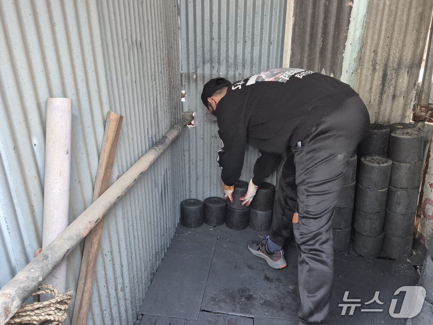 본문 이미지 - 열린마음봉사단이 7일 울산 남구 선암동의 한 마을에서 에너지취약 계층의 창고에 연탄을 쌓고 있다.202512.8/뉴스1ⓒ 뉴스1 박정현 기자