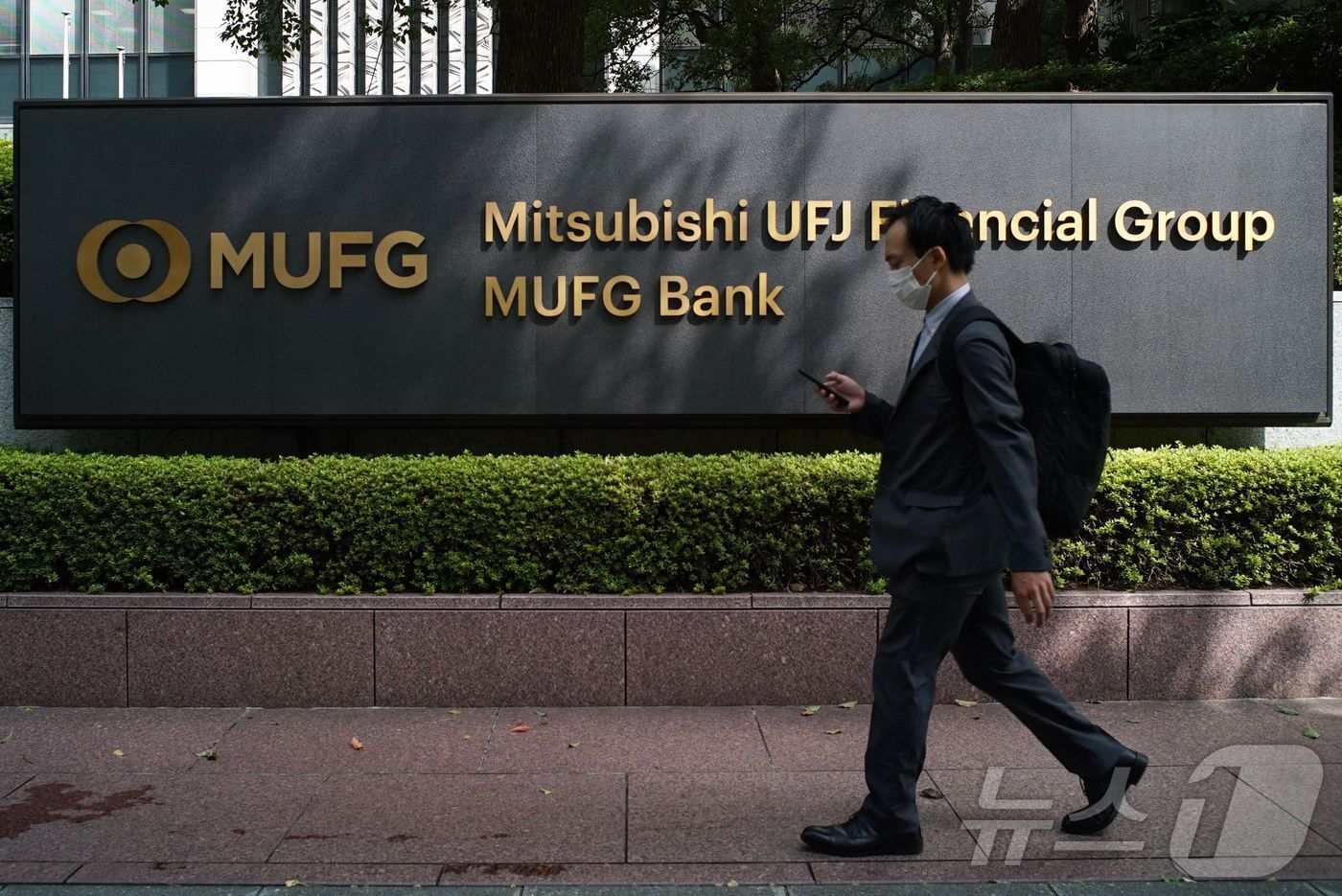 본문 이미지 - 일본 도쿄에 있는 미쓰비시 UFJ 파이낸셜 그룹과 MUFG 은행 본사 앞 간판을 한 보행자가 지나가고 있다. 2021.9.22. ⓒ AFP=뉴스1 ⓒ News1 이정환 기자