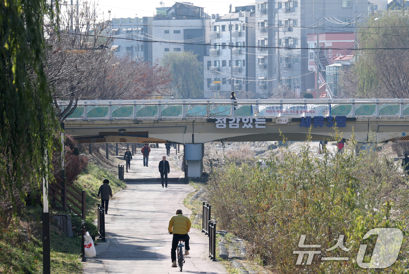 (수원=뉴스1) 김영운 기자 = 포근한 겨울 날씨를 보인 9일 경기 수원시 권선구 세류천에서 시민들이 산책을 즐기고 있다. 2025.12.9/뉴스1