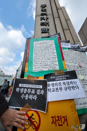 본문 이미지 - 동덕여자대학교 학생들이 9일 오후 서울 성북구 동덕여대 정문 앞에서 제58대 총학생회 비상대책위원회·중앙운영위원회 주최 &#39;공학전환에 대한 8000 동덕인 총투표 결과 전달 기자회견&#39;을 마친 뒤 공학 전환 반대 손팻말을 정문에 붙이고 있다. ⓒ News1 안은나 기자