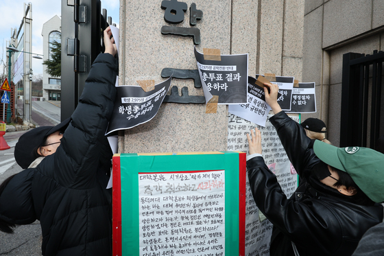 정문에 손팻말 붙이는 학생들